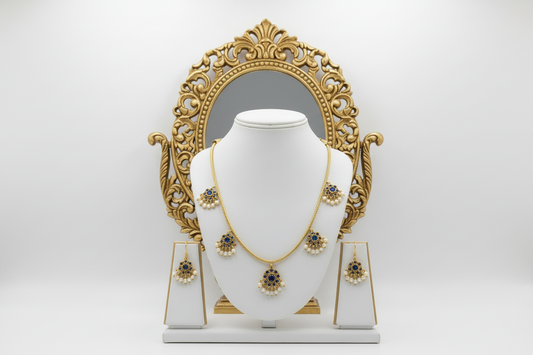 Gold necklace and earrings set on a white mannequin bust with a white background