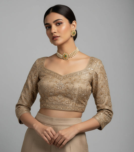 Woman wearing a beige embroidered blouse with a gray background