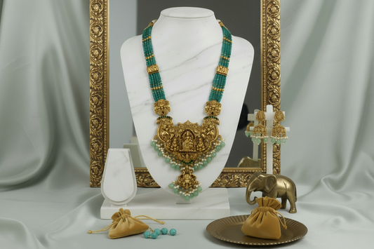 Gold and green south indian bead necklace set on a mannequin with accessories on a light green background