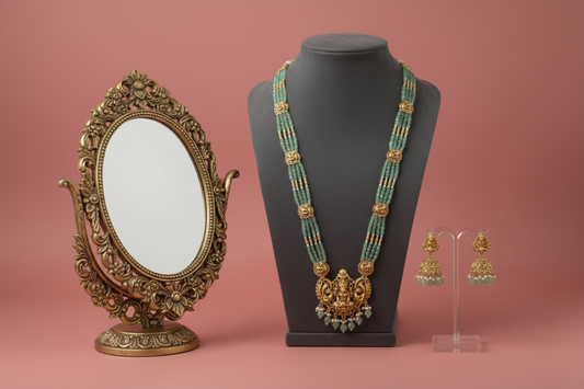 Jewelry set with a necklace and earrings on a mannequin and stand against a pink background