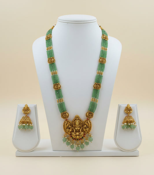 Green beaded necklace with gold accents and matching earrings on a white background