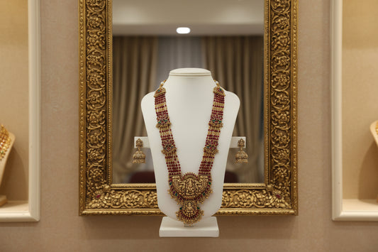 Ornate necklace and earrings on a white fabric background