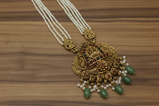 Ornate gold necklace with pearls and green stones on a white background