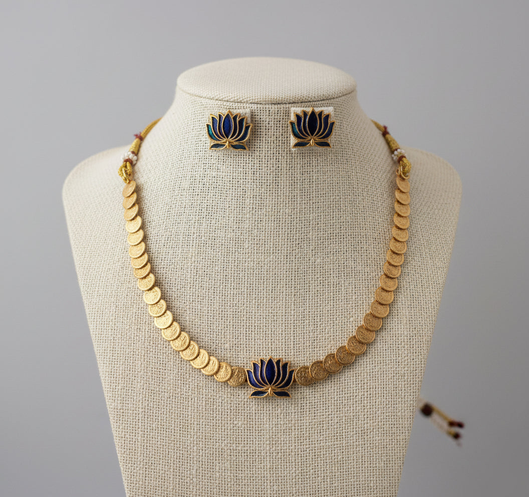 Jewelry set with necklace and earrings featuring gold and blue designs on a gray background
