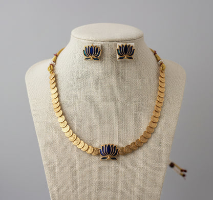 Jewelry set with necklace and earrings featuring gold and blue designs on a gray background