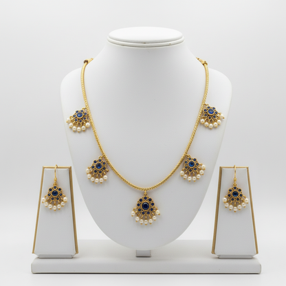 Gold necklace and earrings set on a white mannequin bust with a white background