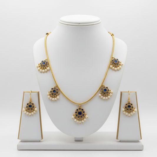 Gold necklace and earrings set on a white mannequin bust with a white background