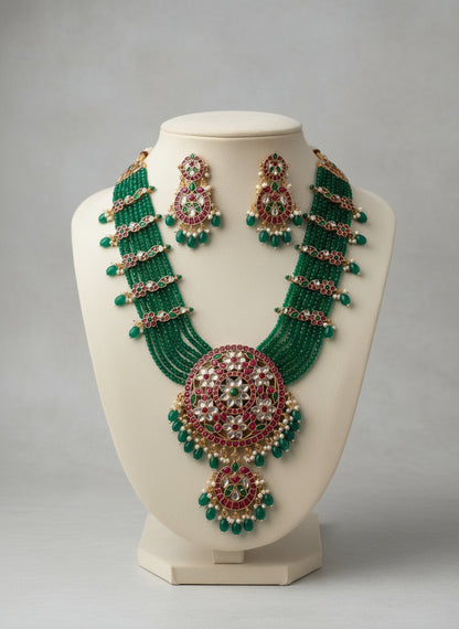 Green and red beaded necklace and earrings on a mannequin bust against a gray background