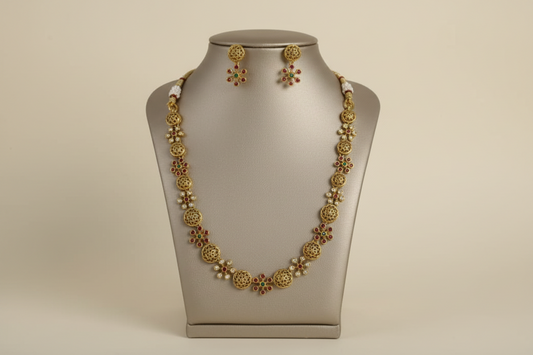 Gold necklace and earrings on a mannequin bust against a beige background