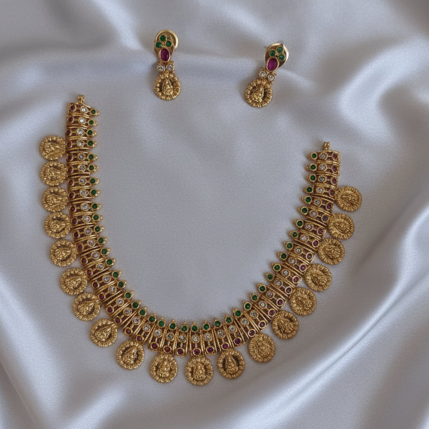 Gold necklace and earrings on a white background