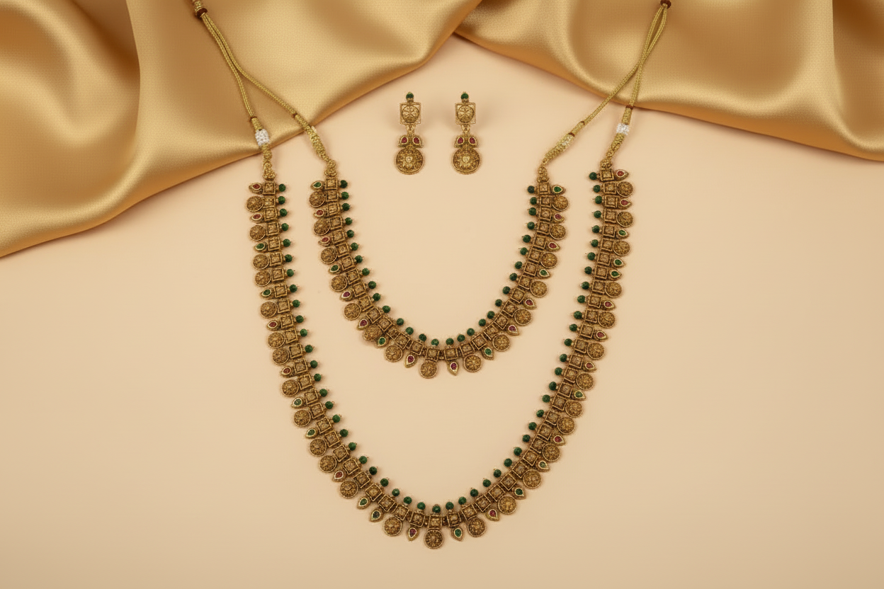 Gold necklace and earrings on a orange fabric background