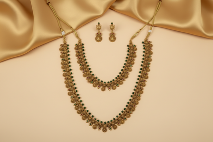 Gold necklace and earrings on a orange fabric background