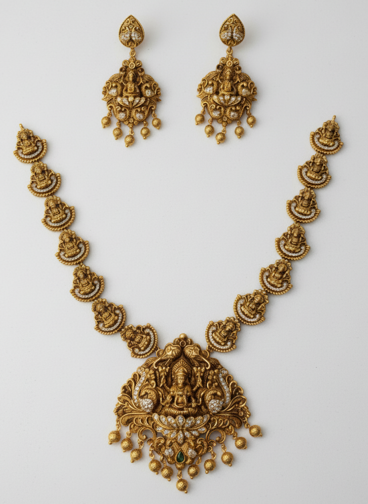 Gold necklace and earrings set on a light gray background