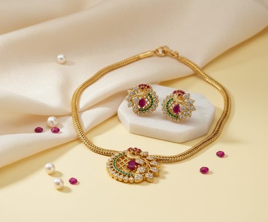 Gold necklace and earrings with gemstones on a beige fabric background