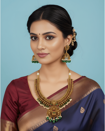 Woman wearing a traditional saree with jewelry against a blue background