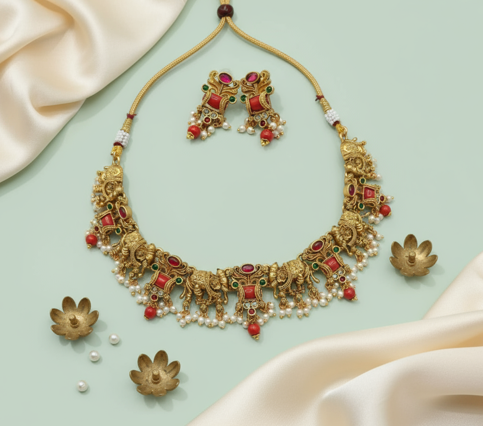 Gold necklace with red and green stones on a light green background