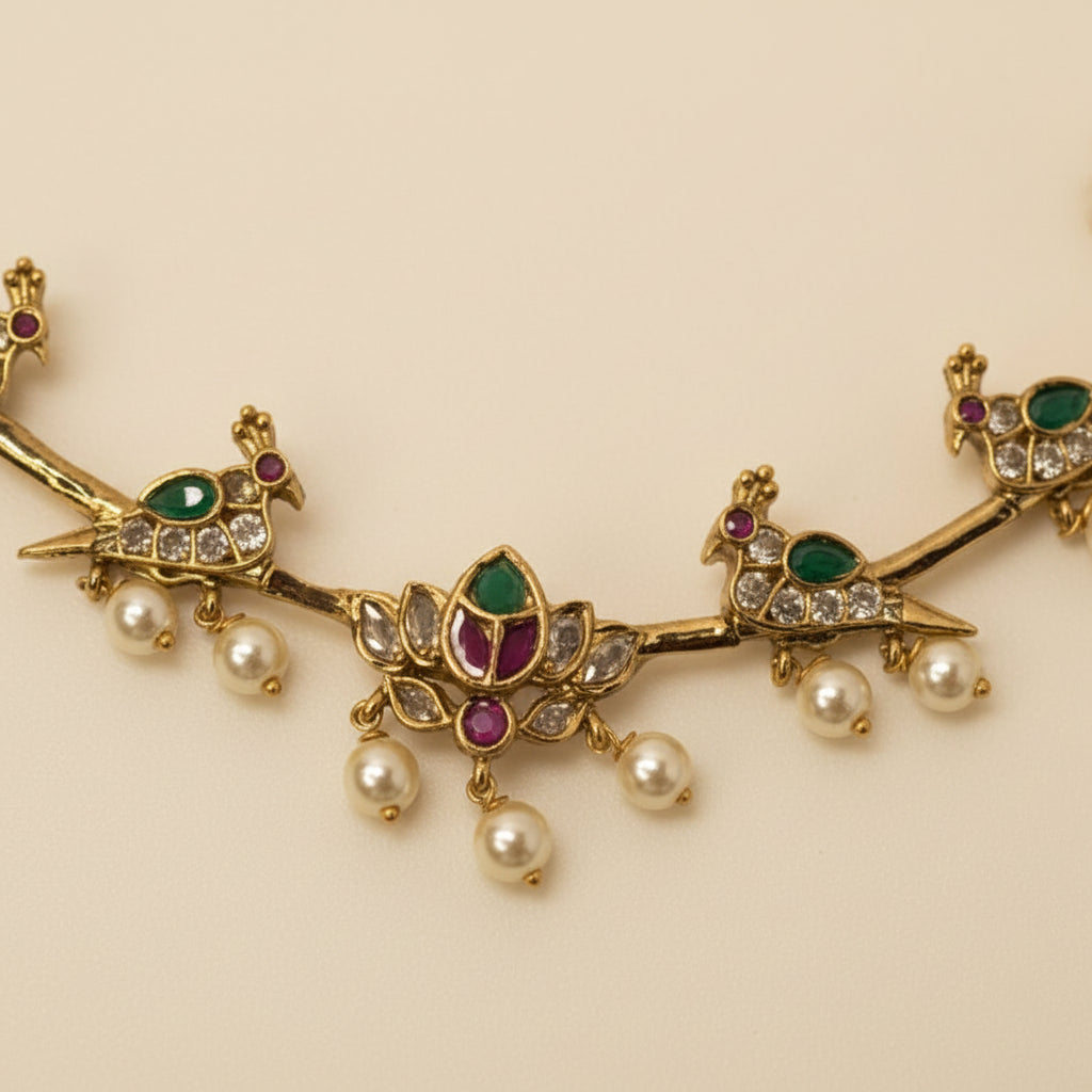 Gold necklace with emeralds, rubies, and pearls on a light gray background