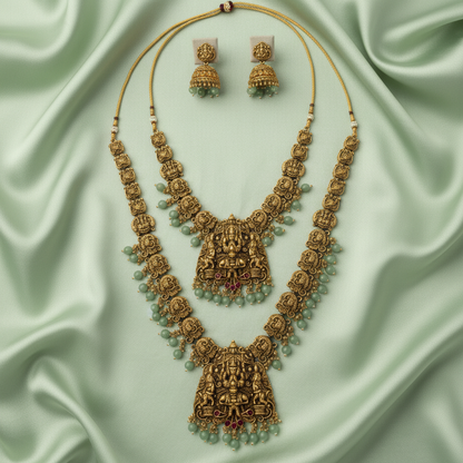 Ornate gold necklace with green beads on a light green fabric background