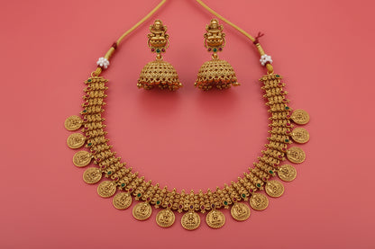 Gold necklace and earrings on a red background