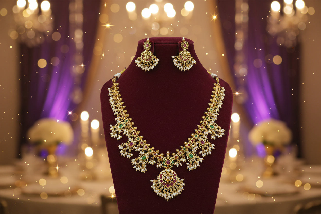 Gold necklace with green and red stones on a maroon stand