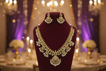 Gold necklace with green and red stones on a maroon stand