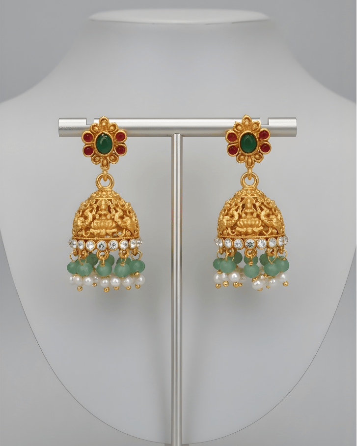 Gold earrings with green and red stones on a white background
