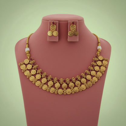 Gold necklace and earrings set on a pink mannequin with a green background