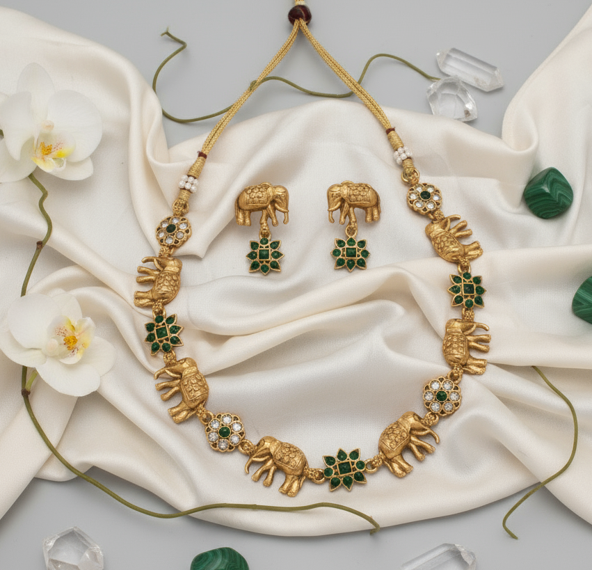 Gold necklace with elephant designs on a white background