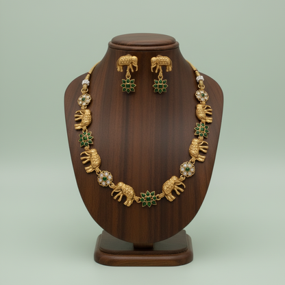 Gold necklace and earrings set on a wooden mannequin against a light green background