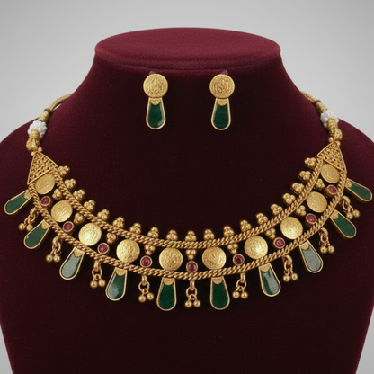 Gold necklace with green stones on a red velvet stand against a gray background
