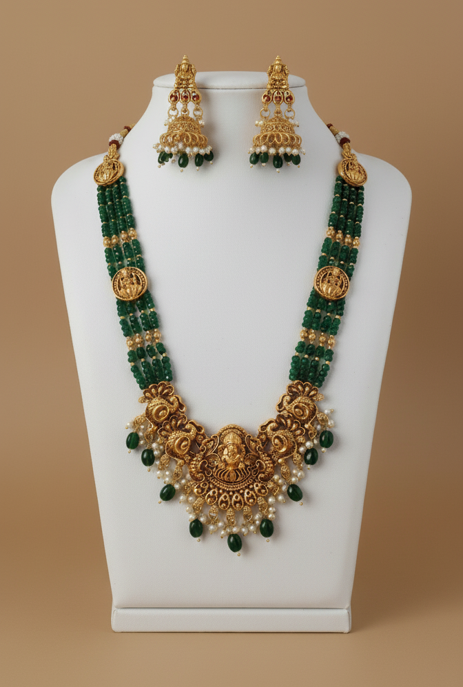 Gold and green beaded necklace set on a mannequin bust against a beige background
