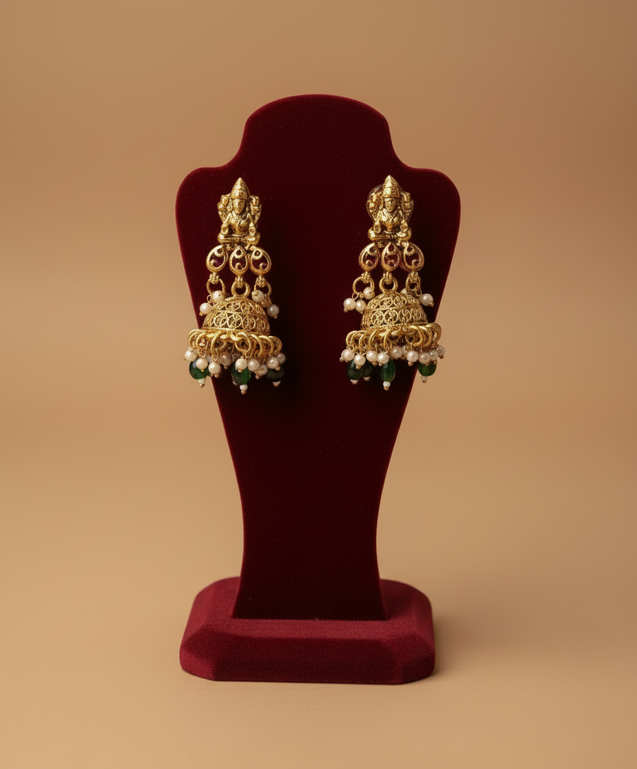 Gold earrings on a red stand 