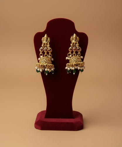 Gold earrings on a red stand 