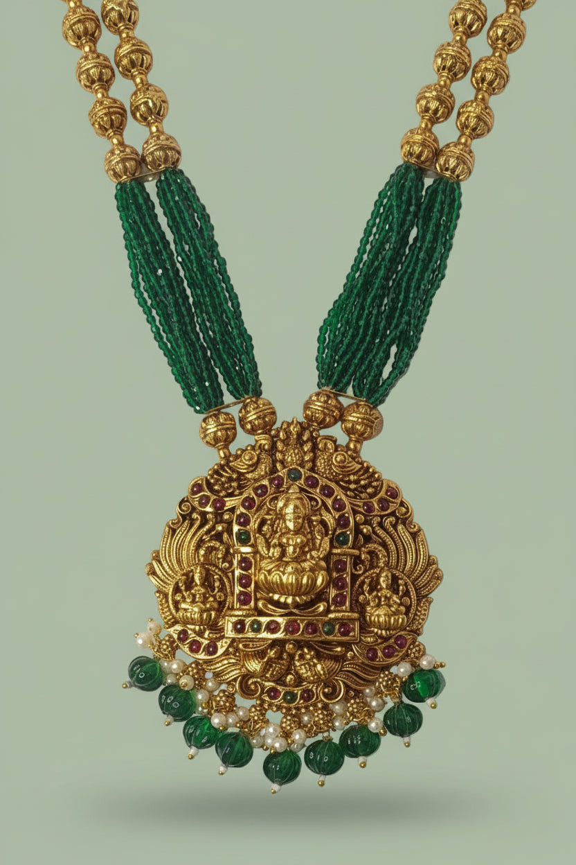 Gold necklace with green beads on a light green background