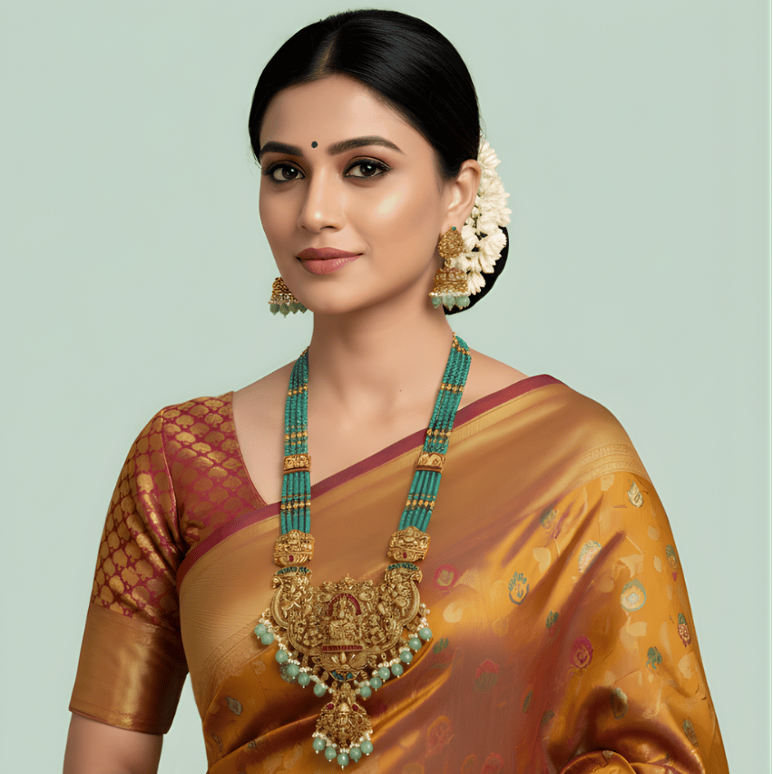 Woman wearing green bead south indian long necklace in a traditional saree with a light green background