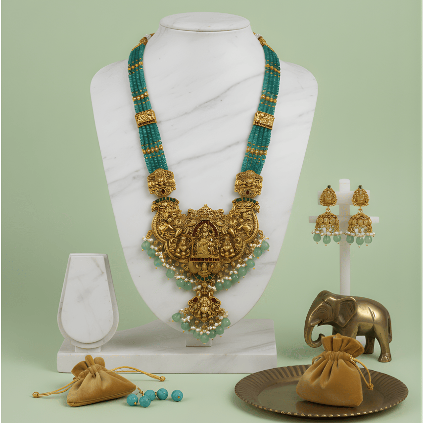 Gold and green south indian bead necklace set on a mannequin with accessories on a light green background