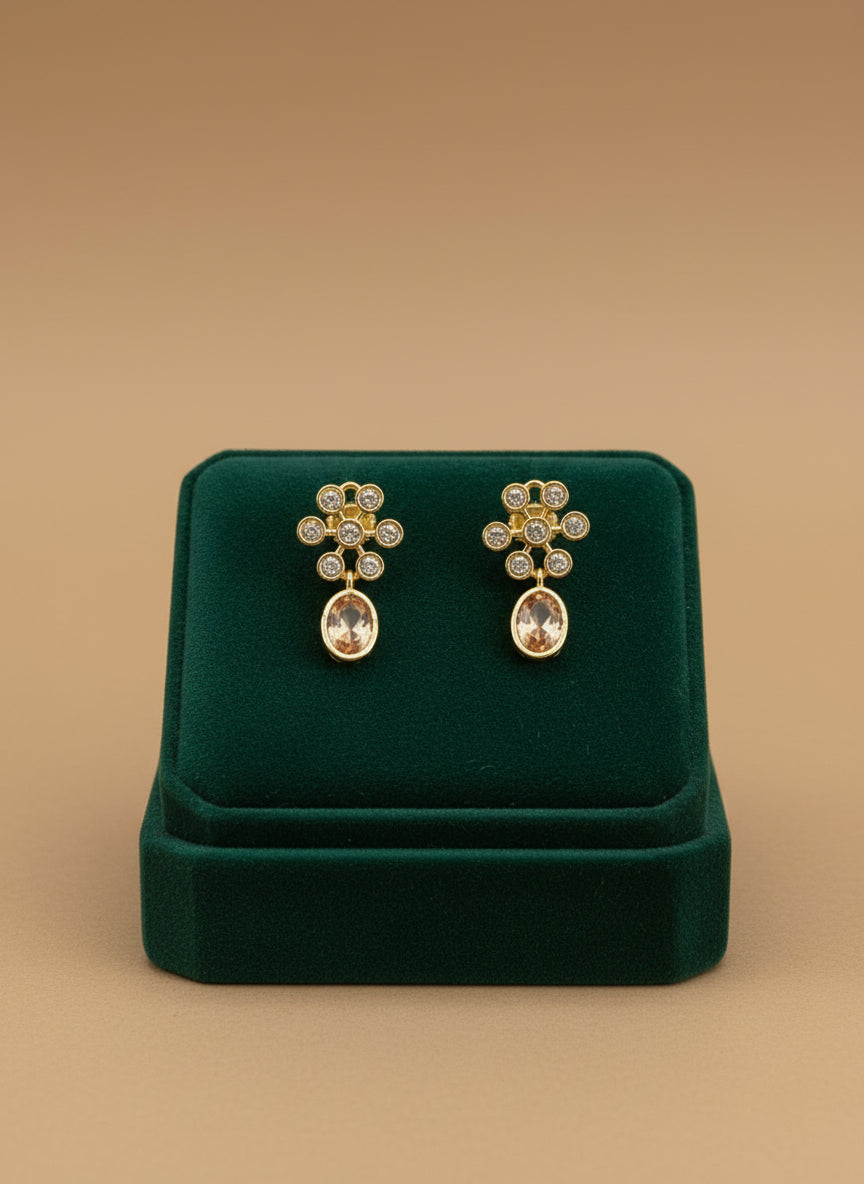 Gold earrings on a white fabric background