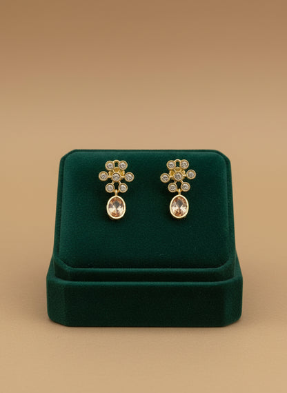 Gold earrings on a white fabric background