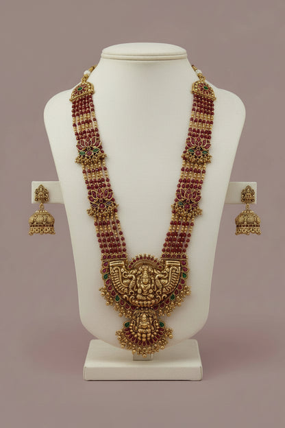 Ornate necklace and earrings on a white fabric background