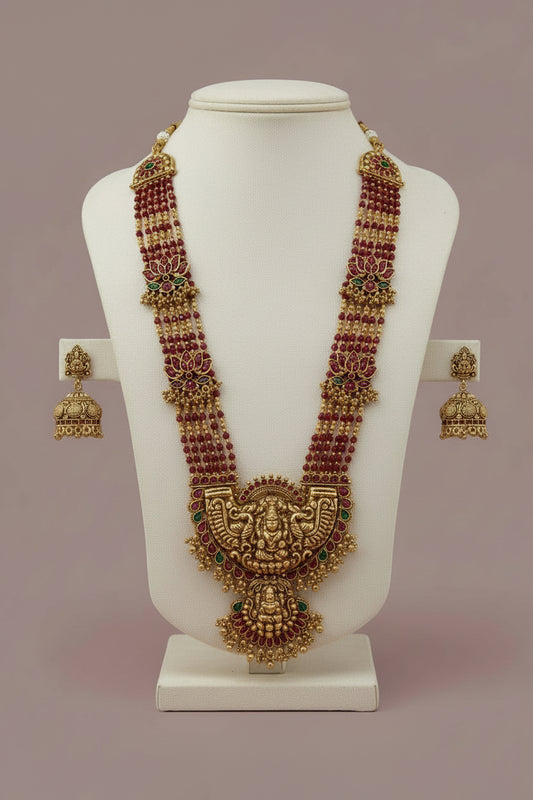 Ornate necklace and earrings on a white fabric background