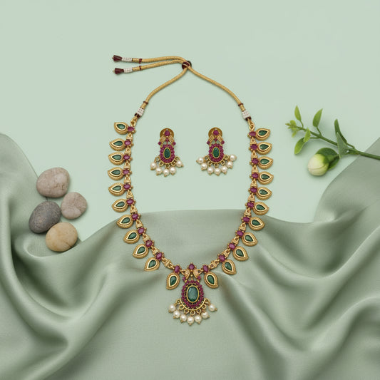 Jewelry set with necklace, earrings, and bangles on a green fabric background