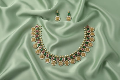 Jewelry set with necklace and earrings on a green satin fabric background