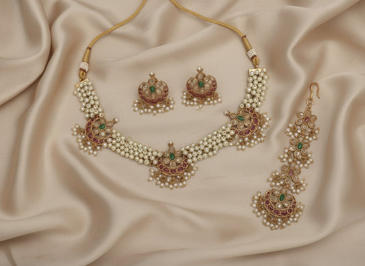 Jewelry set with necklace, earrings, and ring on a beige fabric background