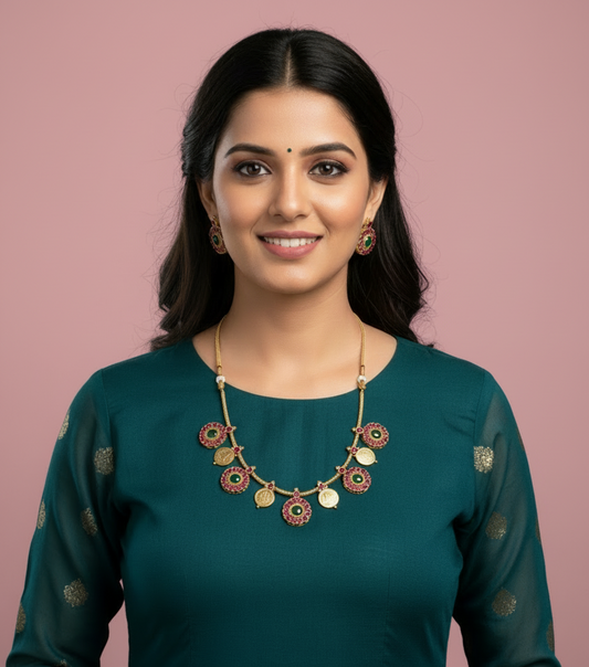 Woman wearing a green traditional outfit with a decorative necklace on a gray background