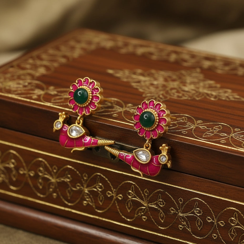 Pair of ornate earrings with floral design on a white fabric background