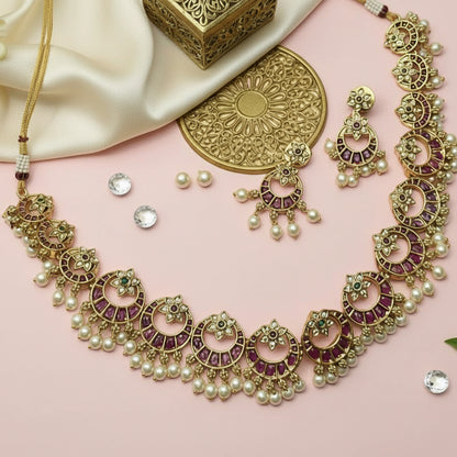 Ornate necklace with matching earrings on a beige fabric background