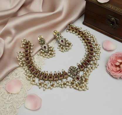 Ornate necklace with red stones and pearls on a soft fabric background