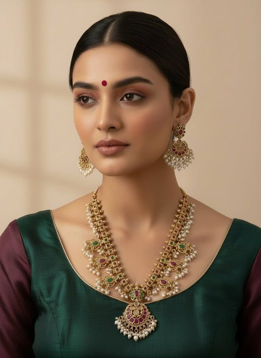 Gold necklace and earrings set on a white background