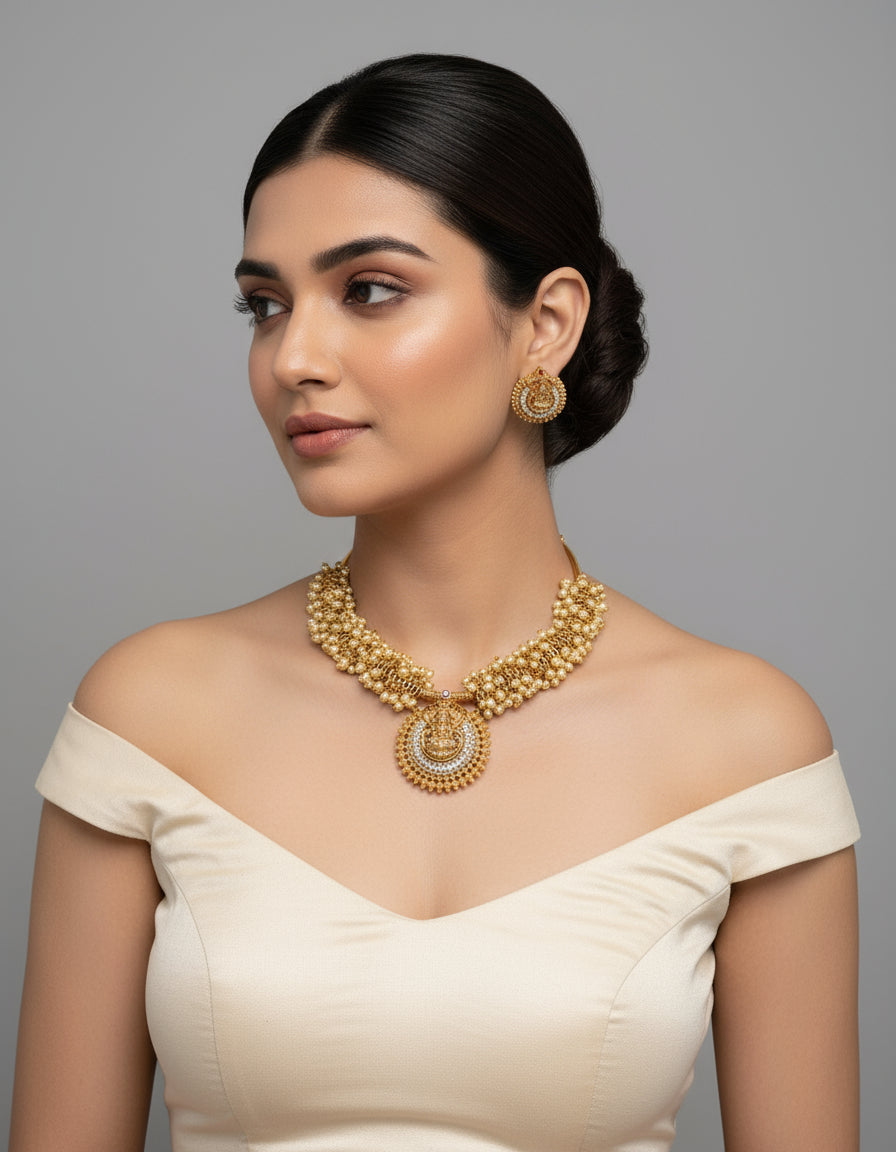Woman wearing a gold necklace and earrings on a gray background
