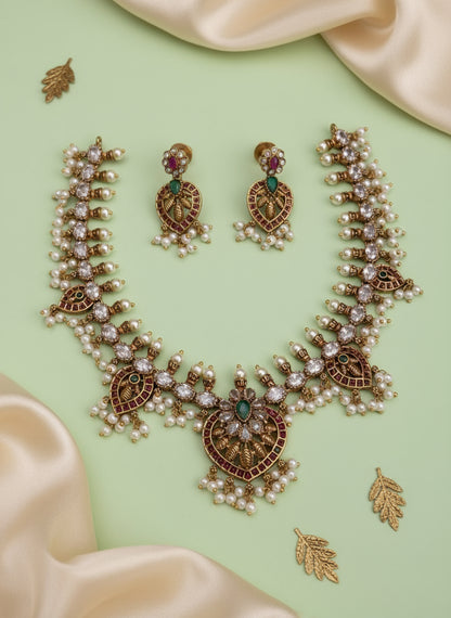 Ornate necklace and earrings set on a beige fabric background 